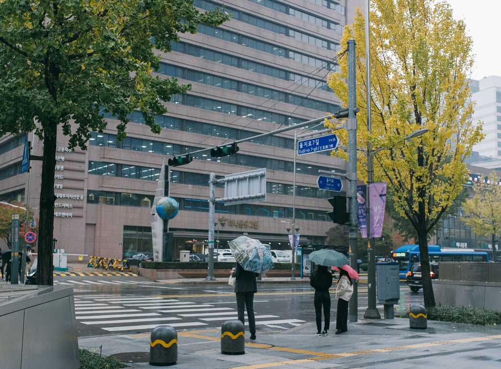 People with umbrellas on a rainy street in Seoul, South Korea