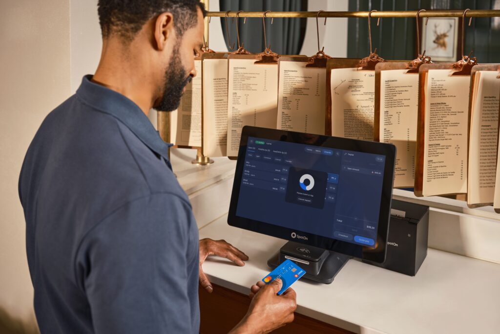 Traveler inserting a physical credit card into a payment terminal
